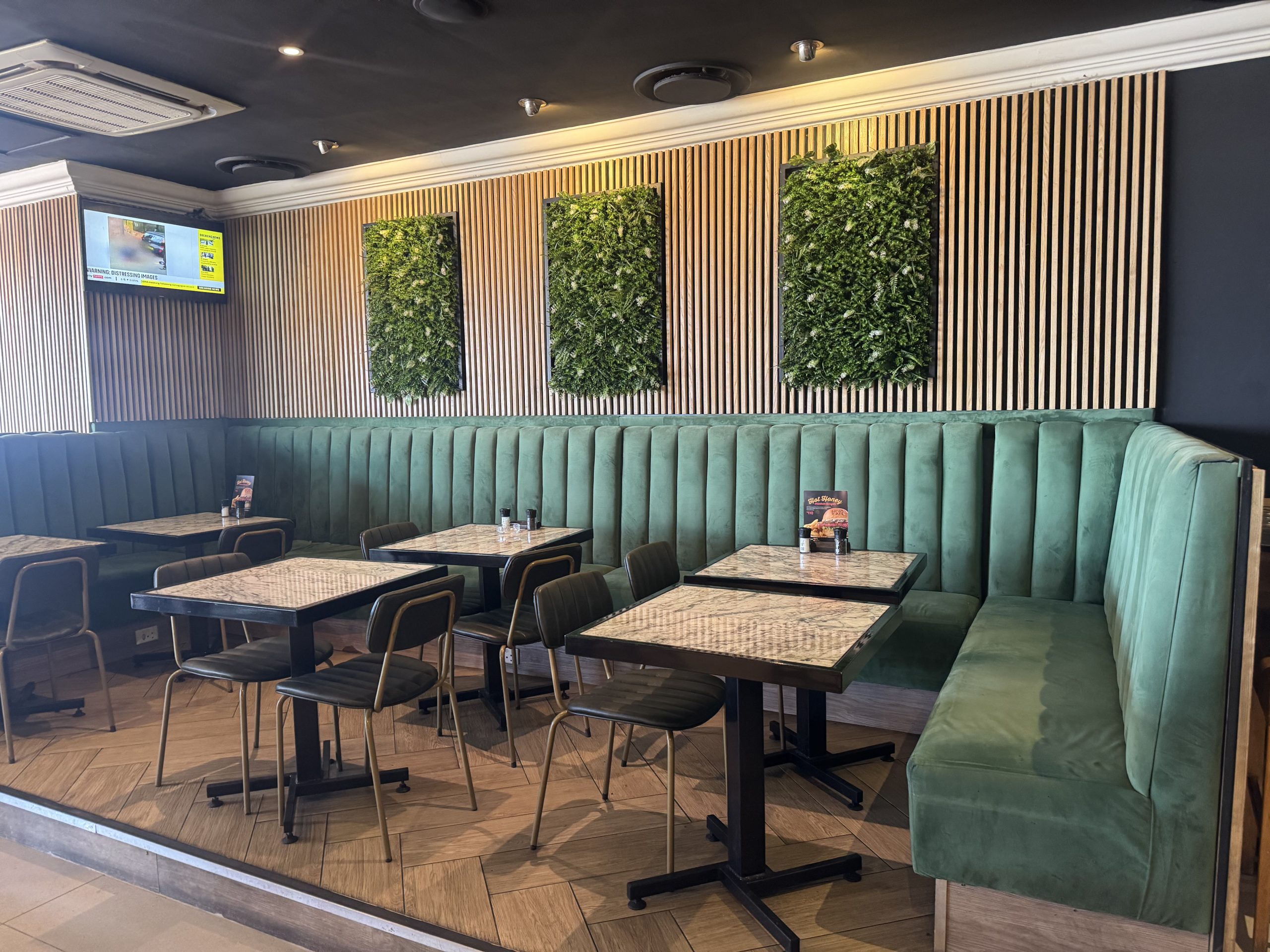 Green couch with wooden tables for dining